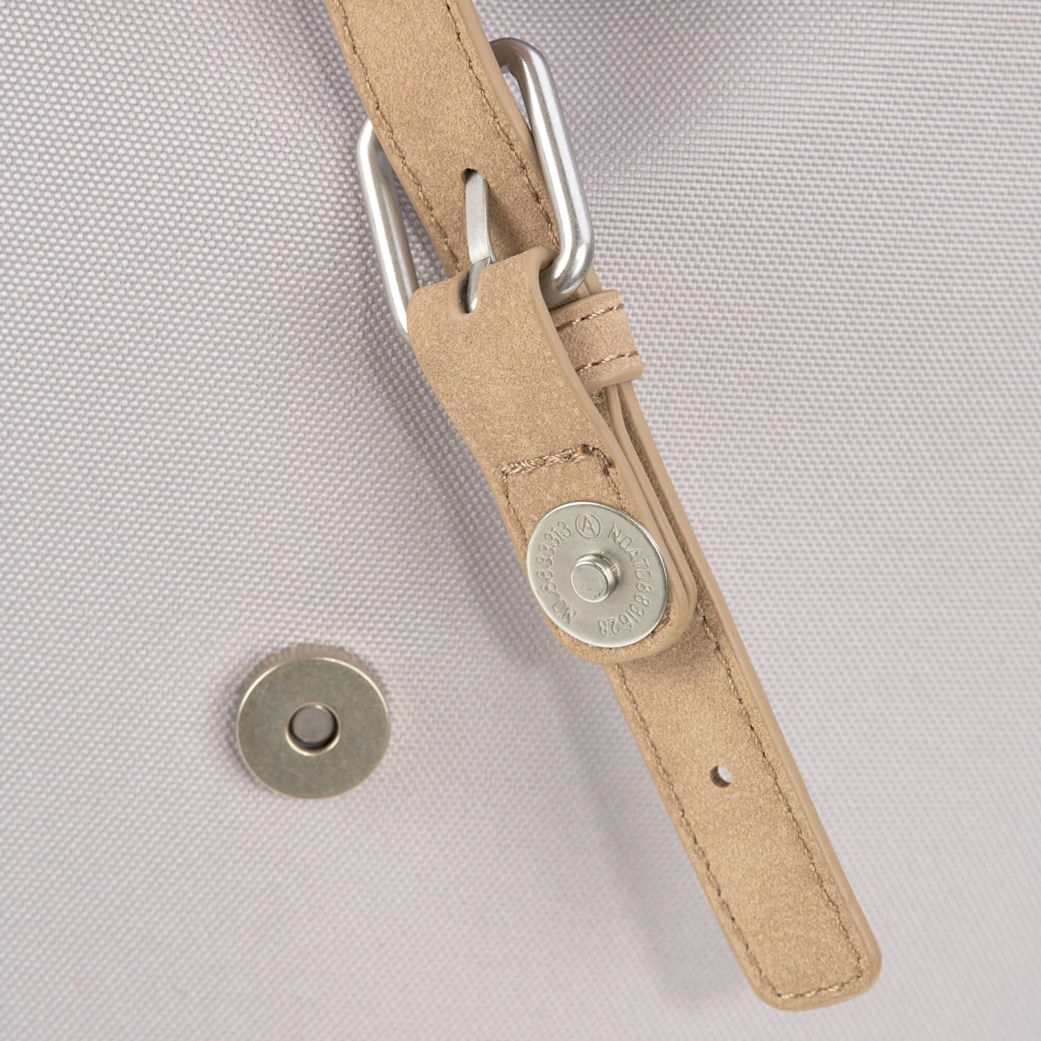 メインポケットの留め具のベルト先端はマグネットボタンなので、ワンタッチで素早く開閉可能。